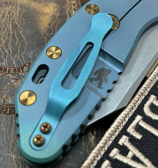 High Res Battle Green Hinderer XM-24 Skinny Wharncliffe Translucent Green G10 with S45VN Working Finish Blade Black Nitride and Bronzed Out Hardware Squatched