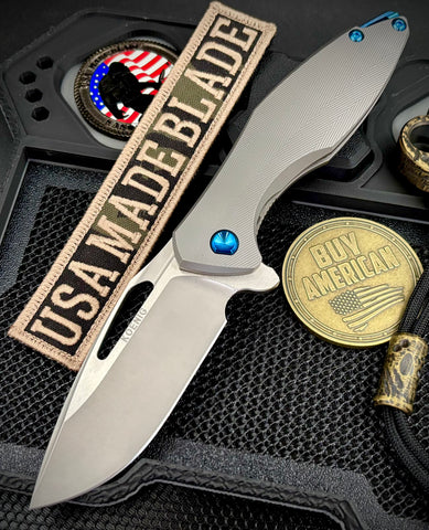 Koenig Arius Patterned Ti Stonewashed M390 Blade with Polished Flats and Blue Ti Hardware AR111211221