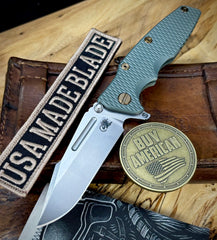 Ammo Can Green Hinderer Eklipse 3.5" Skinny Fullered Harpoon Spearpoint Textured Anodized Working Finish Ti Presentation Side, Smooth Lockside, and Stonewashed Magnacut Blade with bronzed out hardware