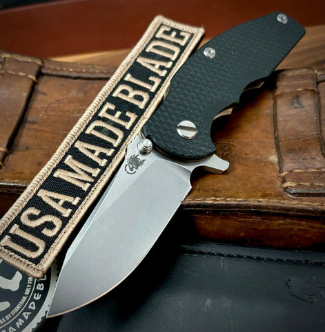 Hinderer Jurassic Hollow Ground Slicer Black G10 Bronze Ti Magnacut Stonewashed Blade