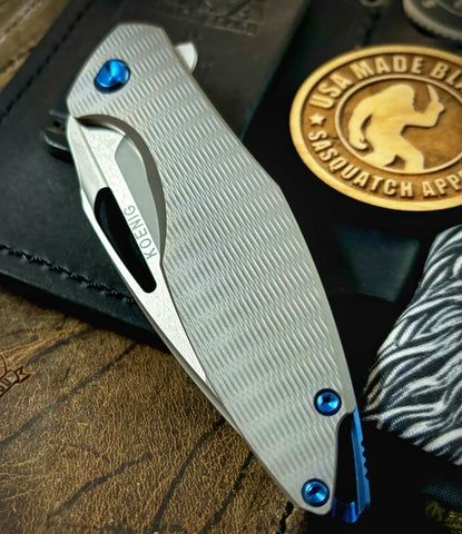 Koenig Mini Arius with M390 Burnished Blade with Polished Flats Plexa Ti and Blue Ti Hardware