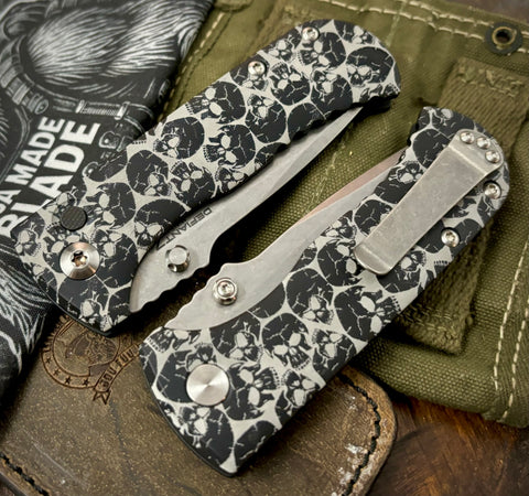 Defiant-7 Talos Button Lock Skull Patterned Handles with Magnacut Blade and Black Hardcoat Anodized Aluminum Handles